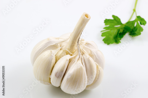 Garlic with leaves of parsley isolated on white background, Garlic and parsley leaves.