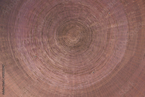 Abstract detail of a bronze base made up of concentric circles and drawn inside each other.