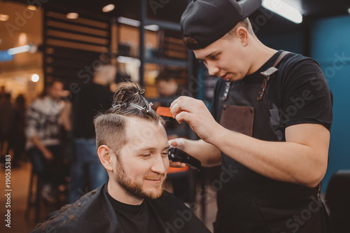 Barber shop. Customer man smiles and laughs during haircuts in Barbershop