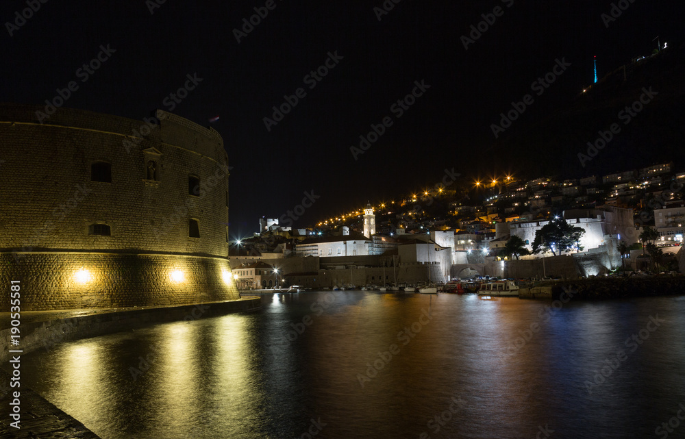 Dubrovnik nochyu, view of the fortress and the city wall with reflection in the water