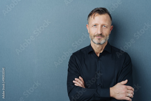 Serious middle-aged man with folded arms photo