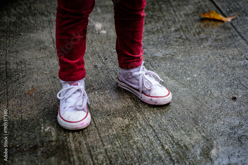 Girls legs in red pants, with shoes wet and dirty with paint © jpbarcelos