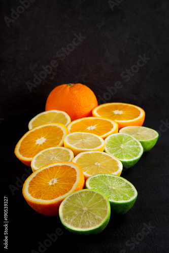 freshly sliced oranges, lemons and limes decorated on a slate plate can be used as a background © Kanea