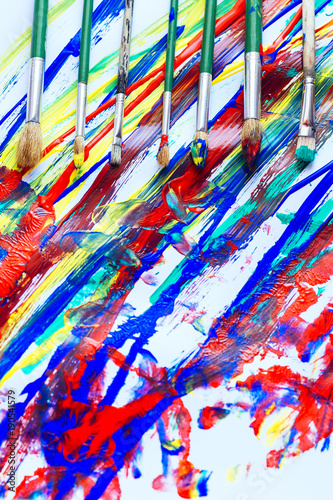 Paint brushes on a colorful background