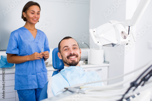 Male is sitting satisfied after treatment in dental office