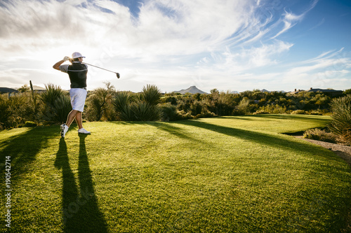 Full length of golfer playing on field against sky photo