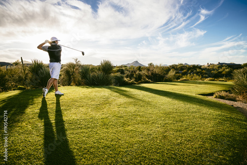 Full length of golfer playing on field against sky