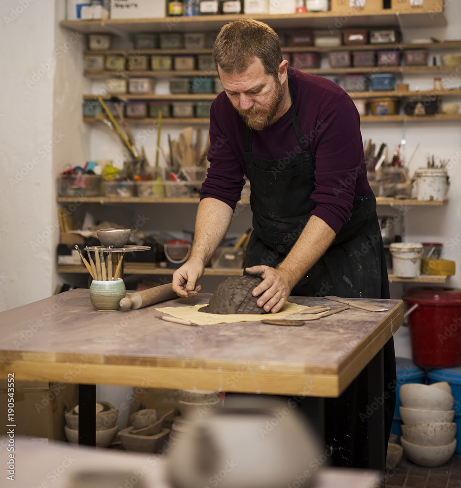 Skilled master preparing clay workpieces for new his creations Skilled master preparing clay workpieces for new his creations