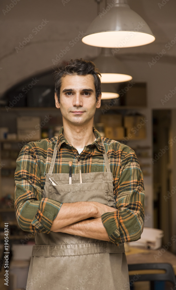 Fototapeta premium Handsome young man posing in pottery workshop