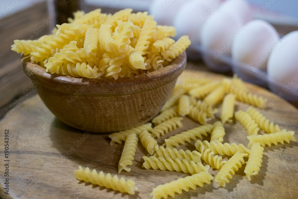 Italian fusilli pasta, raw food on wooden background.
Italian fusilli pasta, raw food on wooden background.