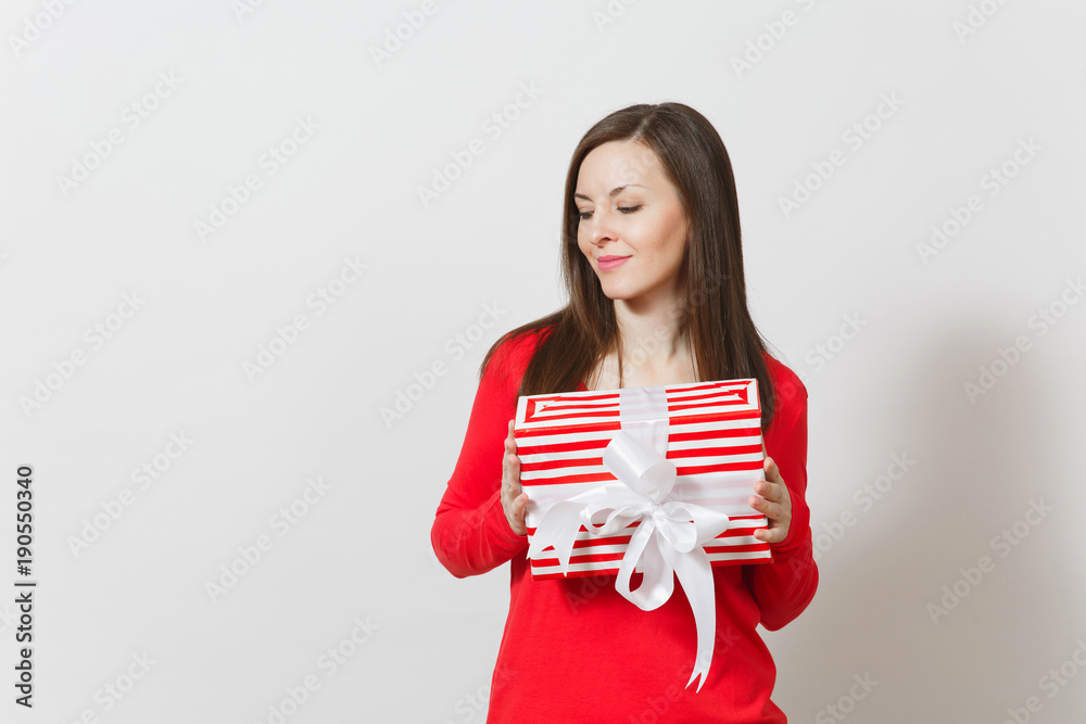Smiling woman holding red striped present box with ribbon, bow isolated on white background. For advertisement. St. Valentine's Day, International Women's Day, Christmas, birthday, holiday concept. Smiling woman holding red striped present box with ribbon, bow isolated on white background. For advertisement. St. Valentine's Day, International Women's Day, Christmas, birthday, holiday concept.
