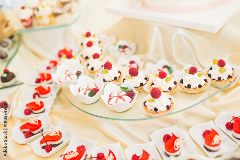 Delicious and tasty dessert table with cupcakes shots at reception closeup Delicious and tasty dessert table with cupcakes shots at reception closeup