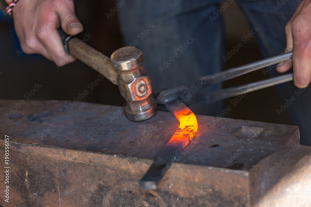 farrier making a traditional horseshoe on a forge