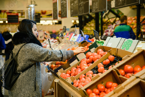 woman choose tomatos in the store photo