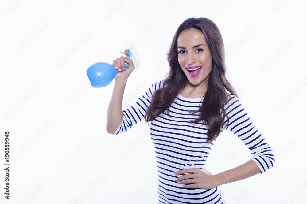 House cleaning. A cheerful beautiful and energetic young woman with a nebulizer in her hands is cleaning her apartment. Means to clean glass. House cleaning. A cheerful beautiful and energetic young woman with a nebulizer in her hands is cleaning her apartment. Means to clean glass.
