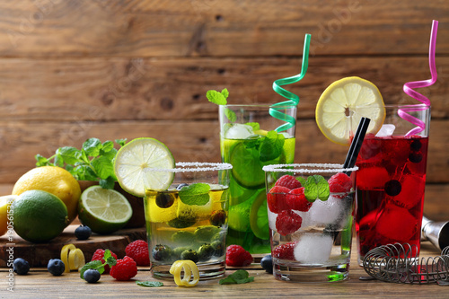 cocktail di frutta sfondo quattro bicchieri con acqua  frutti di bosco e agrumi