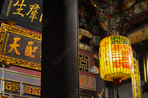 The buddhist Dalongdong Baoan Temple in Taipei city, Taiwan. Indoor shrine showing paper lamps and roof inscriptions.