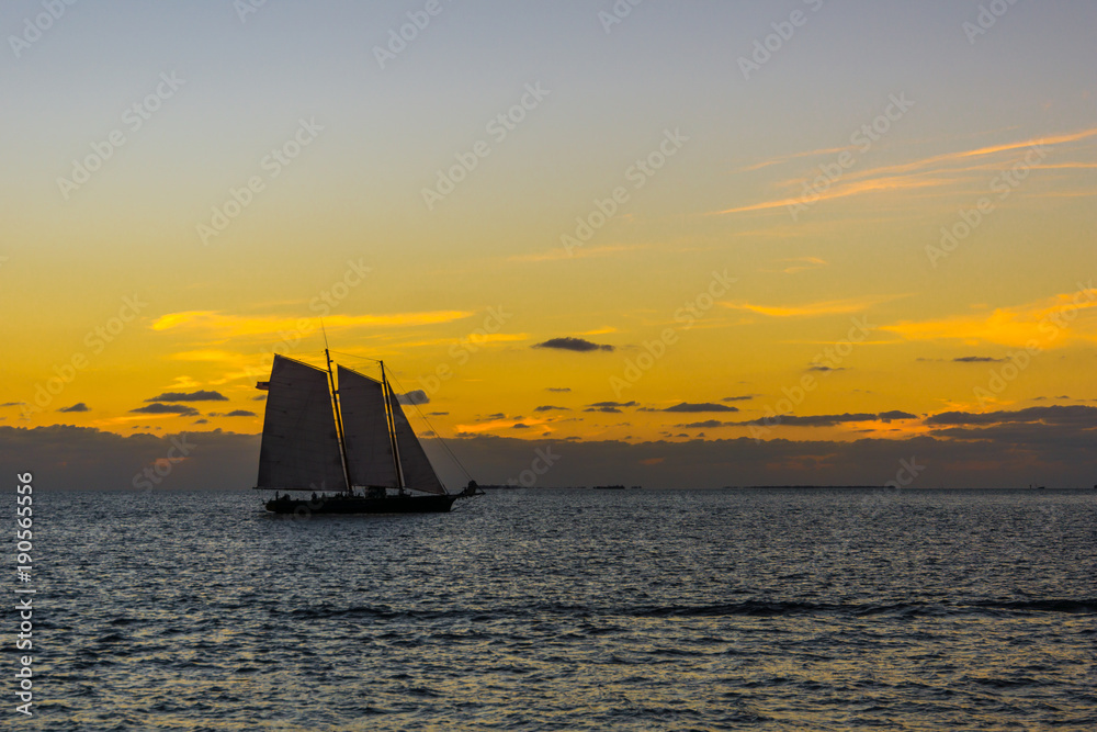 USA, Florida, Ancient sailing boat on the water at key west after sunset with orange burning sky
