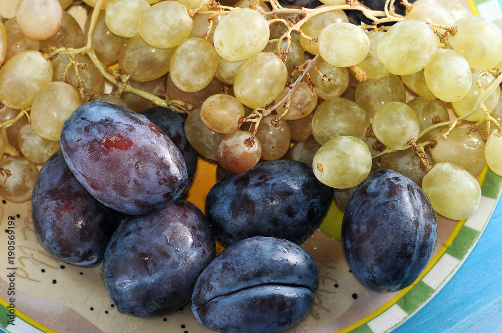Fototapeta premium fruit plate plums and grapes in a plate