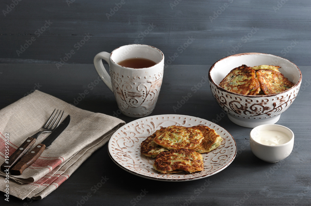 fritters of zucchini with tea on rusticbackground fritters of zucchini with tea on rusticbackground