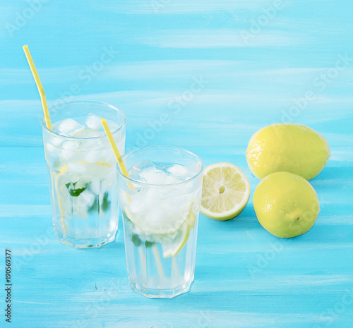 homemade lemonade with straws for drinking - lemon  mint  ice and water in glasses