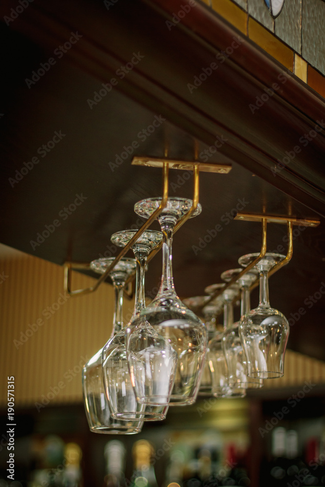 Wine glasses in a bar on wooden rack. Wine glasses in a bar on wooden rack.