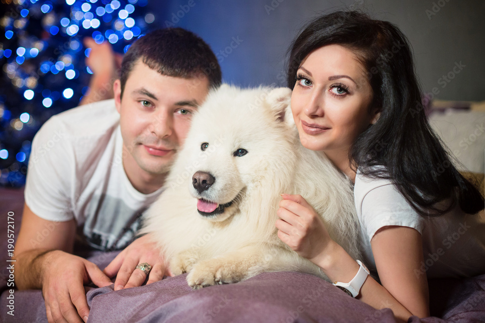 couple in love with a dog in bed couple in love with a dog in bed