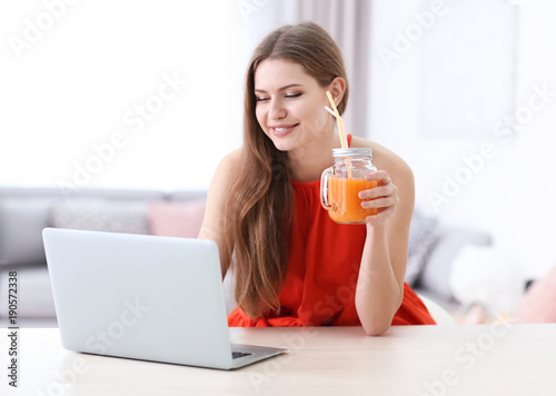 Young woman using laptop in...