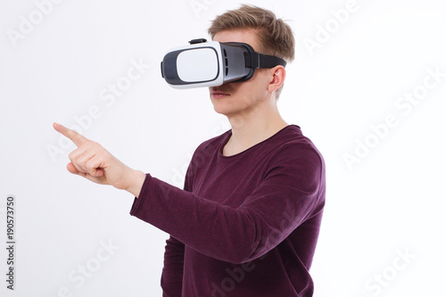 Young Man wearing virtual reality goggles and toch space by finger isolated on white background. VR concept and copy space. Selective focus. Blank template Shirt