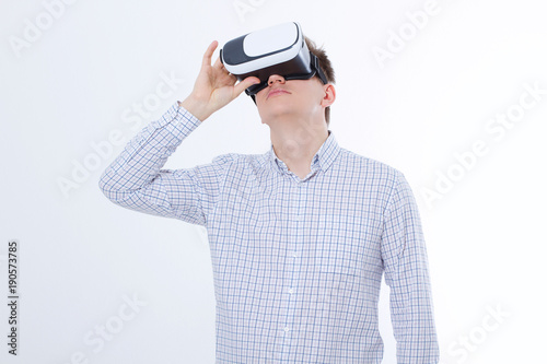 Young business man in vr glasses, goggles watching virtual reality isolated on white background. Copy space and mock up