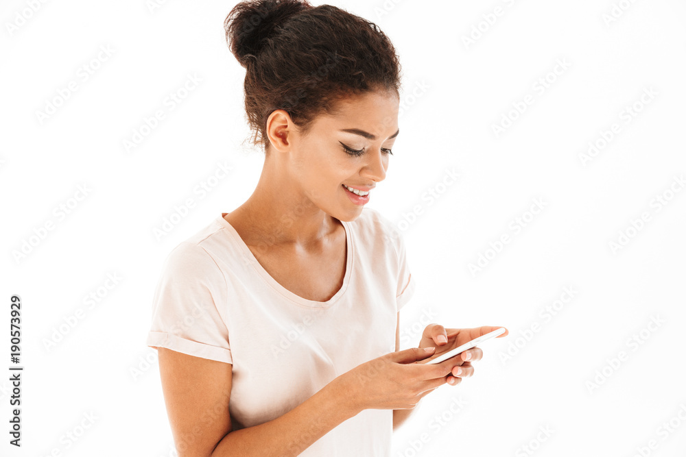 Portrait closeup of mixed race woman in casual typing or using smartphone holding in hands isolated over white background Portrait closeup of mixed race woman in casual typing or using smartphone holding in hands isolated over white background