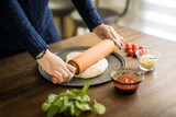 Female hands preparing pizza dough