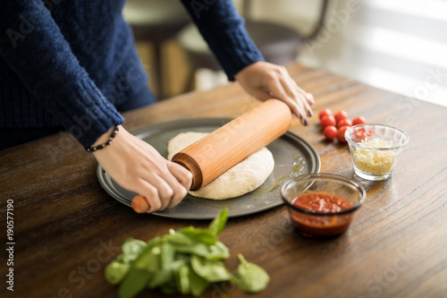 Female hands preparing pizza dough
