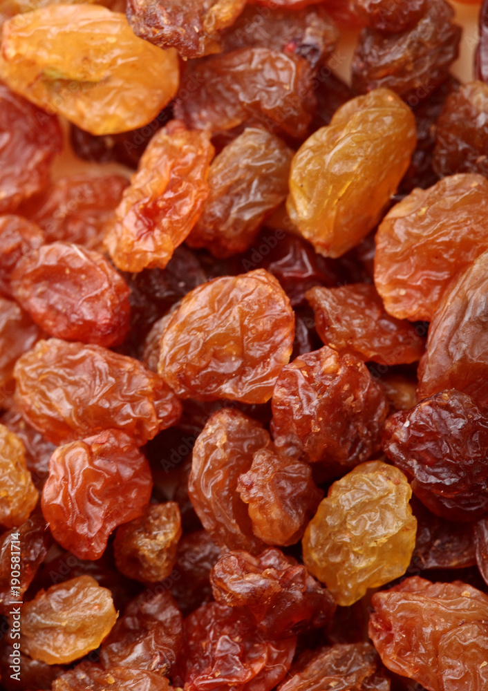 Brown raisin pile. Selective focus. Closeup photo image of brown raisin in a pile present a detail of texture .Texture of raisins