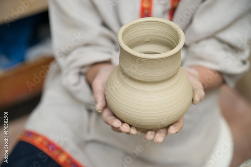 Hands of young potter kneading clay