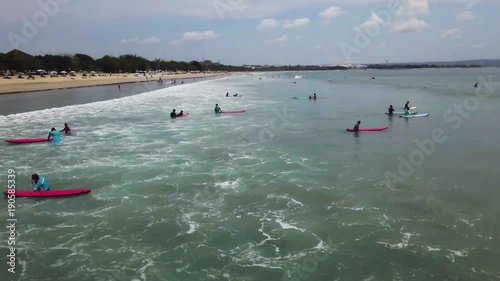 Surfers catching big wave above drone view. Surfer wait for wave. Aerial view of Surfer swimming on board near huge blue ocean wave. Surfer swimming. photo