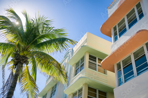 Typical colorful Art Deco architecture with bright backlit palm tree on Ocean Drive in South Beach, Miami, Florida