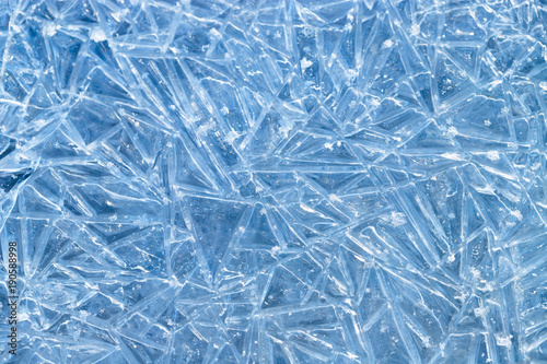 texture frozen natural blue ice crystals close up, top view/ Ice patterns on the water surface of frozen river/ 