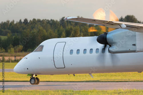 Foto Airplane with turboprop engine with propeller in motion taxing on runway, close
