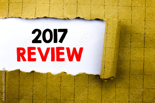 Word, writing 2017 Review. Business concept for Annual Summary Report written on white paper on the yellow folded paper. photo