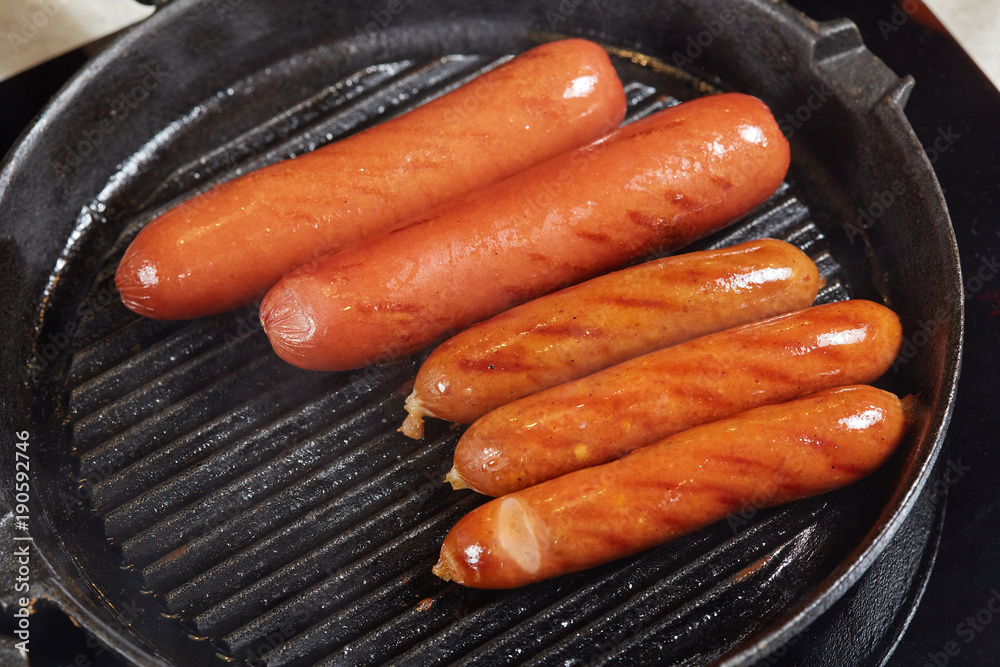 Grilled red hot sausages in frying pan Grilled red hot sausages in frying pan