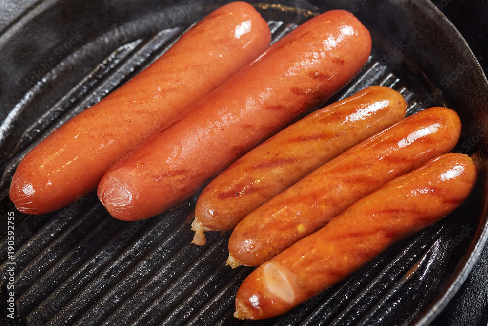 Grilled red hot sausages in frying pan Grilled red hot sausages in frying pan