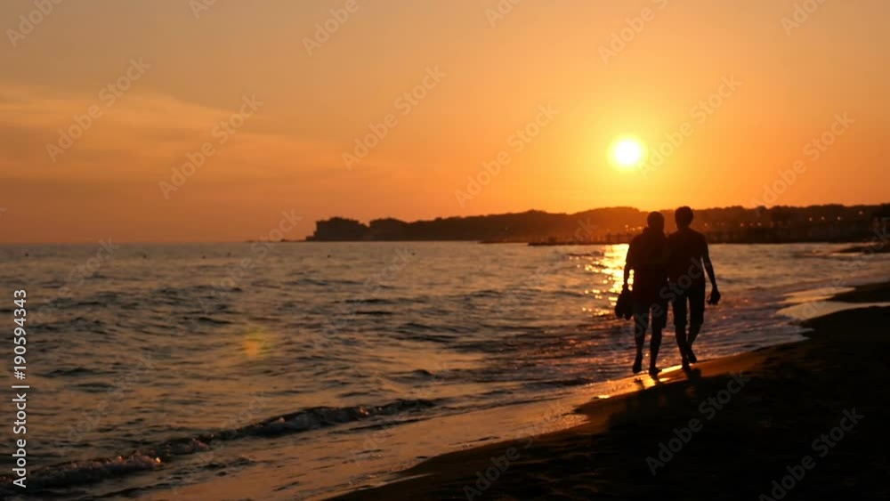 Summer Romantic Sunset: couple walk on the beach Summer Romantic Sunset: couple walk on the beach