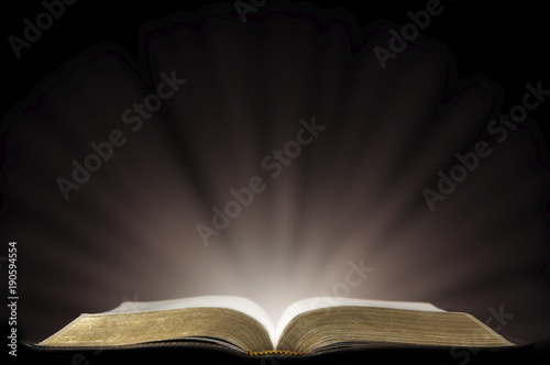 Obraz na plátne A Book that looks like a Bible Open in a Dark Room with Light Pouring Out of it