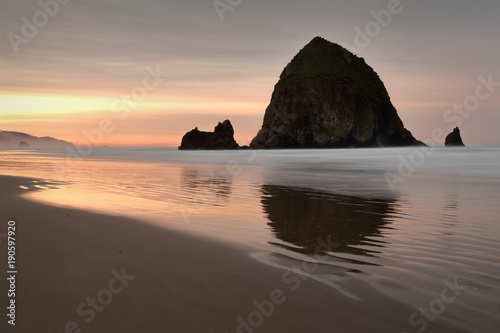 Haystack Rock Beach Sunrise. Sunrise at Haystack Rock in Cannon Beach, Oregon as the surf washes up onto the beach. United States.
