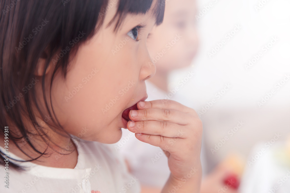 The lovely little girl is eating fruit The lovely little girl is eating fruit