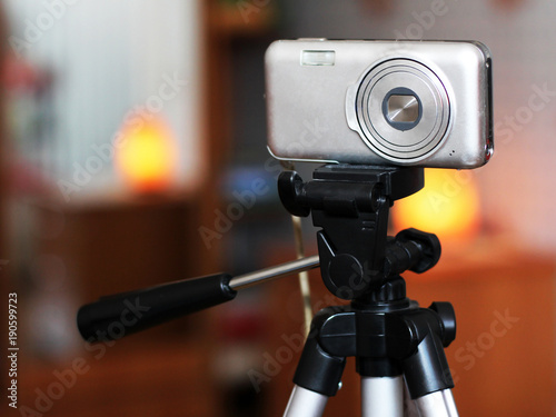 The image of video camera under the tripod in the interior