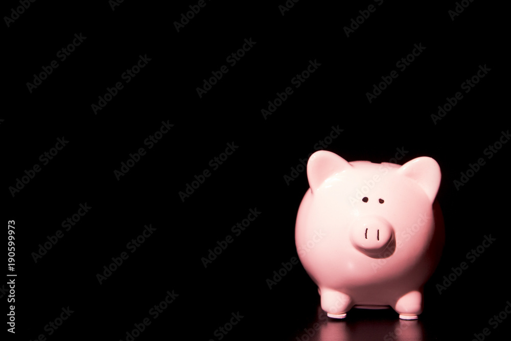 Simple Pink Piggy Bank on a Black Table in a Black Room - Savings can by ominous and difficult Simple Pink Piggy Bank on a Black Table in a Black Room - Savings can by ominous and difficult