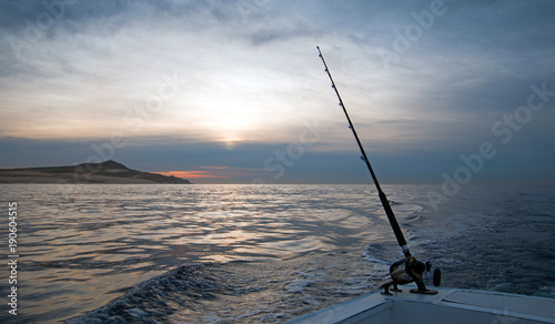 Dawn sunrise view of fishing rod on charter fishing boat on the Pacific side of Cabo San Lucas in Baja California Mexico BCS