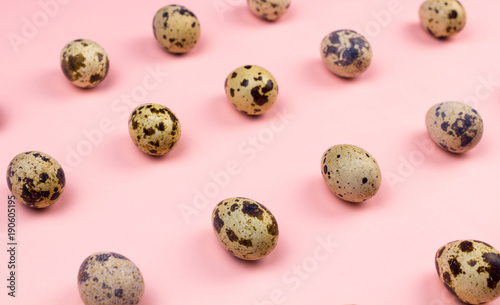 Holiday easter quail eggs on pastel pink background. Close up.